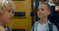 Three teen children standing at open bus door closeup. Boys talking together.