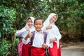 three elementary students standing at the side of country road with thumbs up Royalty Free Stock Photo