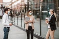 Employers standing in social distance wearing face mask looking at each other and talking