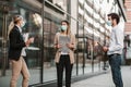 Employers standing in social distance wearing face mask looking at each other and talking