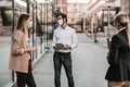 Employers standing in social distance wearing face mask looking at each other and talking