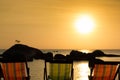 Three empty beach chairs facing the sea at sunset Royalty Free Stock Photo