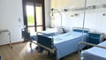 three empty beds in a hospital room