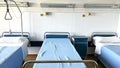 three empty beds in a hospital room