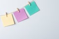 Three empty color papers on thread against white board Royalty Free Stock Photo