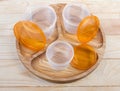 Open round plastic food storage containers on wooden compartmental dish