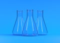 Three empty erlenmeyer flask on blue background