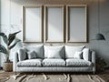Three blank frames on a white concrete wall above a white sofa in a bright living room interior Royalty Free Stock Photo