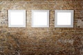 Three empty frames on light brick wall. Blank space posters or art frame waiting to be filled. Square Black Frame Mock Royalty Free Stock Photo