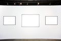 Three empty frames on white wall