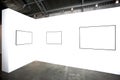 Three empty frames on white wall