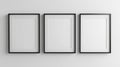 Three Empty Frames on a White Wall Three empty black frames hang on a white wall creating a minimalist and modern design Royalty Free Stock Photo