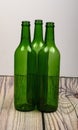 Three empty green glass wine bottles on a wooden table Royalty Free Stock Photo