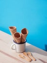 three empty ice cream cones in a white cup on a blue background Royalty Free Stock Photo