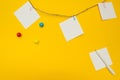 Three empty note papers attached to a rope on a yellow background. flat composition Royalty Free Stock Photo