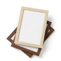 Three empty picture frames stacked in different sizes and colors against a plain background Royalty Free Stock Photo