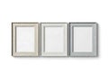 Three empty picture frames in varying neutral tones displayed side by side Royalty Free Stock Photo