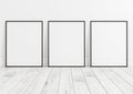 Triple 8x10 Vertical Black Frame mockup on white wooden floor and white wall Royalty Free Stock Photo