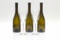 Three empty upturned wine bottles and two glasses on a white background Royalty Free Stock Photo