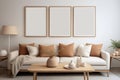 Three empty vertical picture frames in a modern living room with white sofa and beige pillows. Wall art mockup Royalty Free Stock Photo