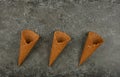 Three empty wafer ice cream cones on gray table