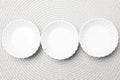 Three empty white plates on gray spiral tissue background Royalty Free Stock Photo