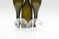 Three empty wine bottles and two glasses close up on a white background Royalty Free Stock Photo