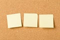 Three empty yellow sticky paper memo notes on cork board