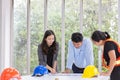 Three engineers working meeting room at the office. Three workers are talking construction plan. Electricians carpenter or