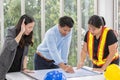 Three engineers working meeting room at the office. Three workers are talking construction plan. Electricians carpenter or Royalty Free Stock Photo