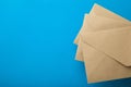 Three envelopes of recycled paper on a blue background, empty space for text