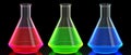 Three Erlenmeyer flasks filled with RGB colored liquids on a black reflective background Royalty Free Stock Photo