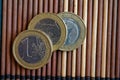 Three euro coins lie on wooden bamboo table Denomination is 1 euro Royalty Free Stock Photo