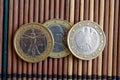 Three euro coins lie on wooden bamboo table in a row Denomination is 2 euro - back side Royalty Free Stock Photo