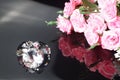 Three excellent diamonds of the first water and bouquet of pink roses with reflection on black mirror background close up view. Royalty Free Stock Photo