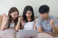 Excited friends or roommates watching tv online in laptop sitting on bed