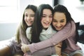 Three excited teenager girls having fun together, enjoying laze leisure time at home