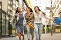 Three fashionable girls walking happy city after shopping. Royalty Free Stock Photo