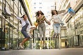 Three fashionable young women strolling with shopping bags. Royalty Free Stock Photo