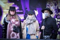 Three fashionably dressed girls in wide-brimmed hats and caps, long woolen coats and raincoats with scarves from Burberry in