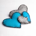 Three felt hearts on a white wooden background, Royalty Free Stock Photo