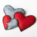 Three felt hearts on a white wooden background