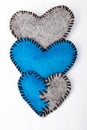 Three felt hearts on a white wooden background Royalty Free Stock Photo