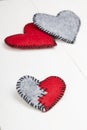 Three felt hearts on a white wooden background Royalty Free Stock Photo