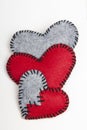 Three felt hearts on a white wooden background Royalty Free Stock Photo