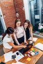 Three female college students working on assignment together using laptop standing at home Royalty Free Stock Photo