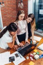 Three female college students working on assignment together using laptop standing at home Royalty Free Stock Photo