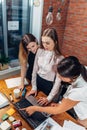 Three female college students working on assignment together using laptop standing at home Royalty Free Stock Photo