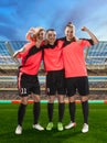 Three female soccer players celebrating victory on soccer filed Royalty Free Stock Photo