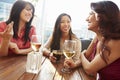Three Female Friends Enjoying Drink At Outdoor Rooftop Bar Royalty Free Stock Photo